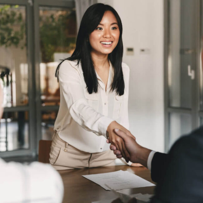 Smiling professional woman shaking hands during a business meeting