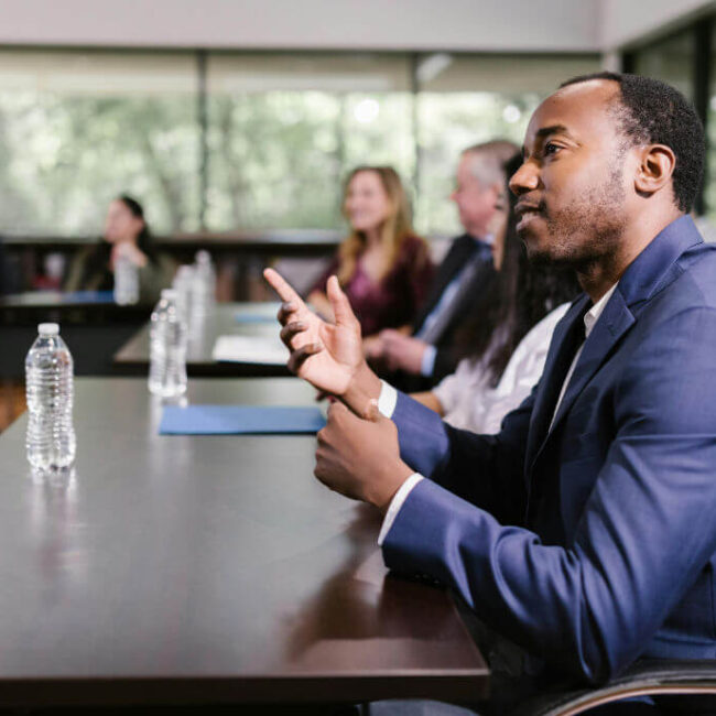 Professional participating in a discussion during a training session with others in a classroom setting.